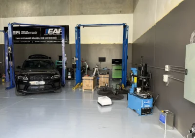 SemCar Automotive Group's Unit 2 workshop floor at 128 Steel Street Capalaba with a Range Rover on the hoist beneath the two brands one workshop banner