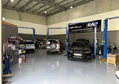 Range Rover and Land Rover vehicles on hoists inside SemCar's Unit 2 workshop, 128 Steel Street Capalaba