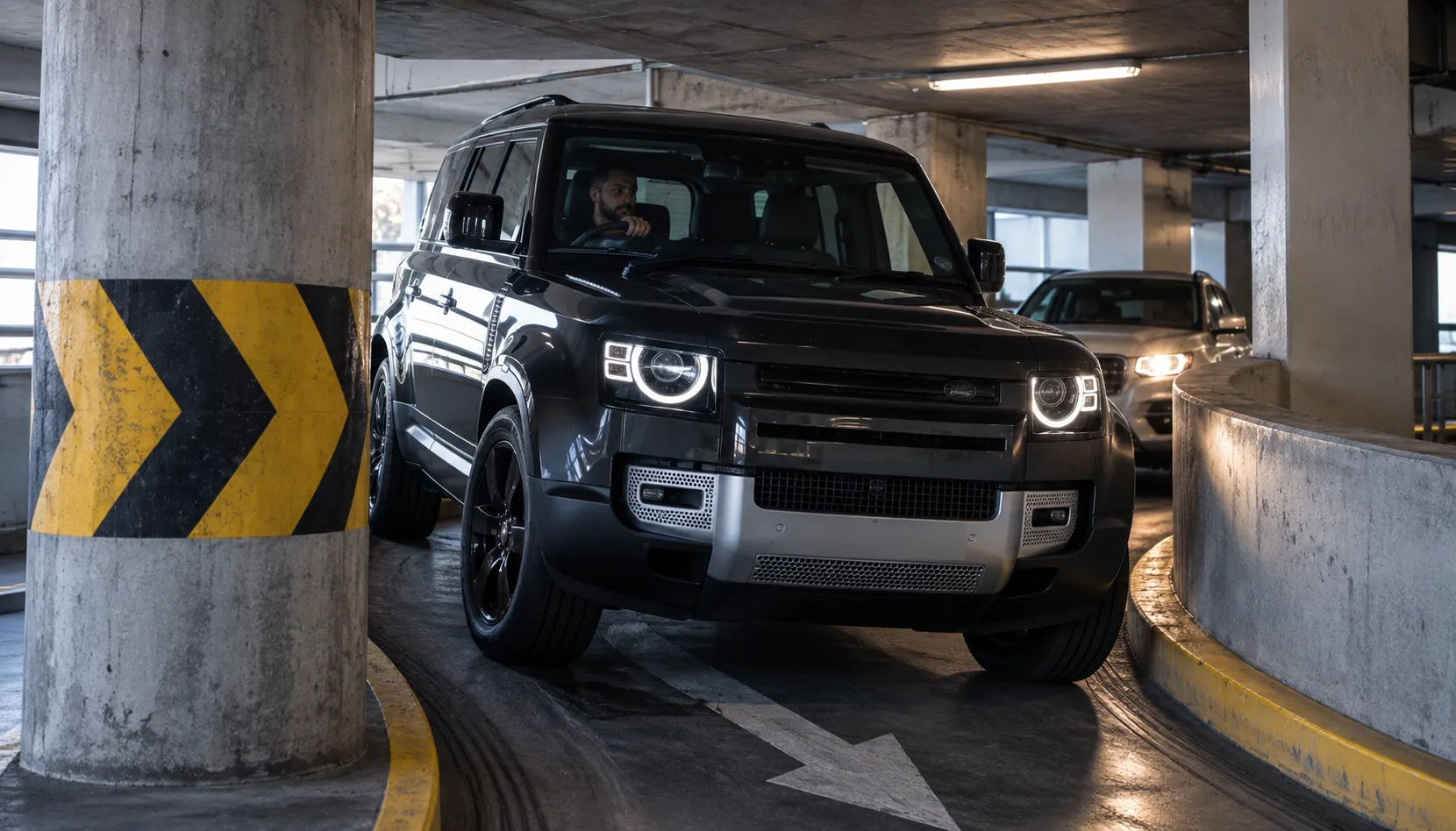 The Parks and Tight Spots It Changes Forever Land Rover Defender navigating between concrete pillars on a tight Brisbane shopping centre carpark ramp where a 3D surround camera helps